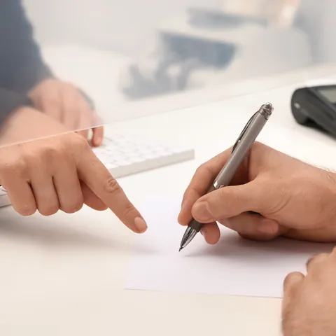 Customer completing a form at a financial service counter