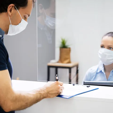 Customer signing paperwork at a financial service counter
