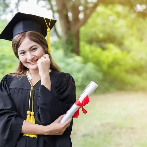 Graduate holding a certificate after receiving an academic award
