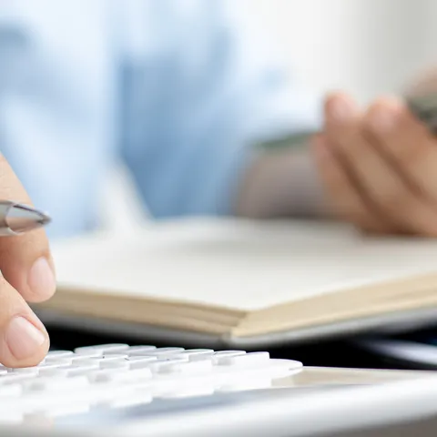 Woman calculating household income and expenses with a calculator