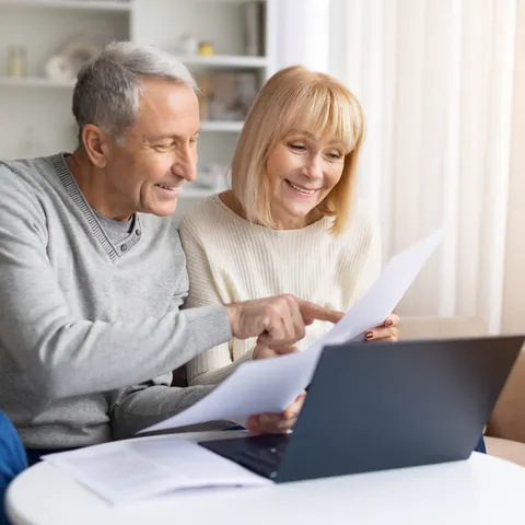 Couple comparing household tax documents on a laptop