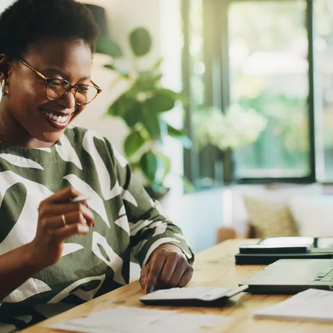 Woman organizing tax documents with a laptop and calculator