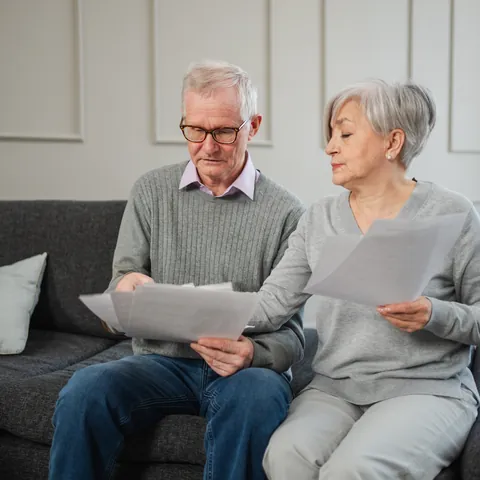 Retired couple reviewing bills and financial documents