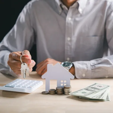 House keys, loan paperwork, and U.S. dollars on a desk