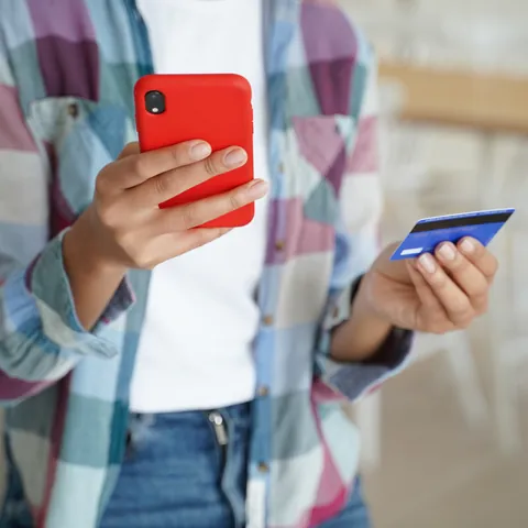 Person using a smartphone and payment card for an online transaction