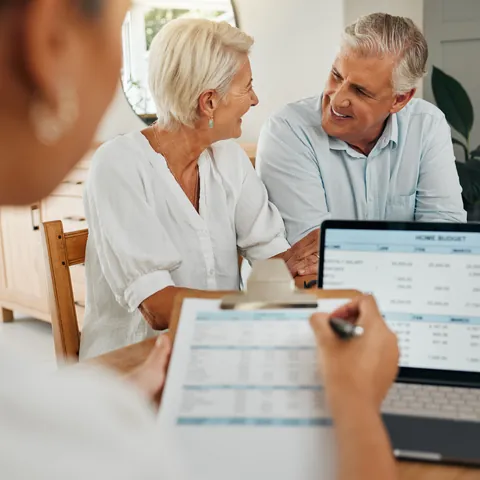 Senior couple reviewing financial paperwork with an advisor