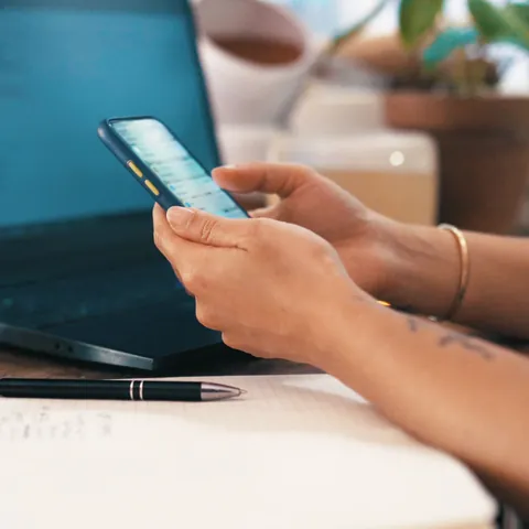 Person researching a small online loan on a smartphone and laptop