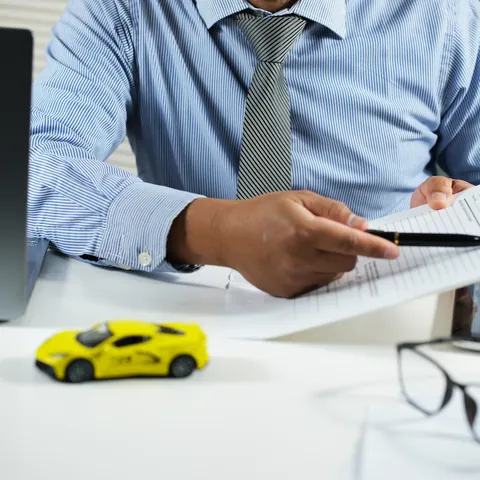 Customer reviewing car title paperwork with a salesperson