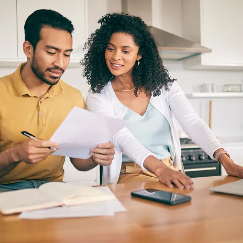 Couple reviewing closing disclosure paperwork at home