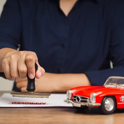 Car loan agreement being stamped approved
