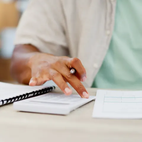 Person reviewing personal loan paperwork with a calculator
