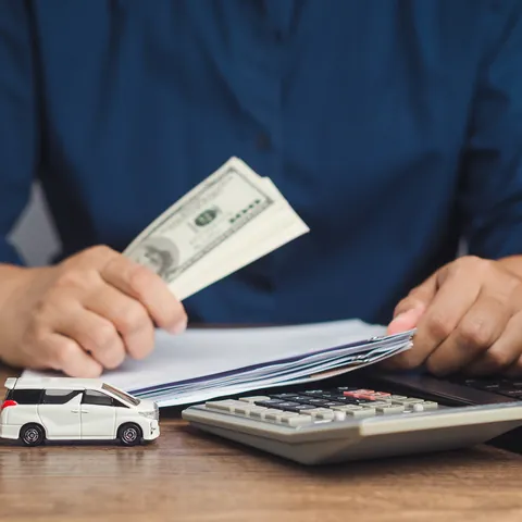 Borrower holding cash while signing title loan paperwork