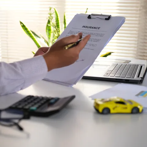 Car title paperwork being reviewed beside a toy car