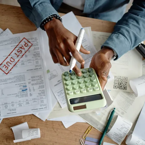 Man organizing bills and past-due notices into a repayment plan