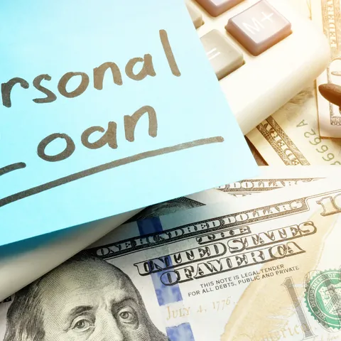 Calculator, cash, and pen used to review a personal loan amount