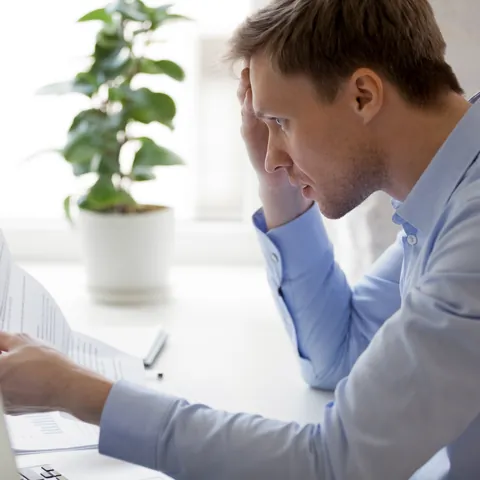 Man reading an unpaid debt notice from a bank