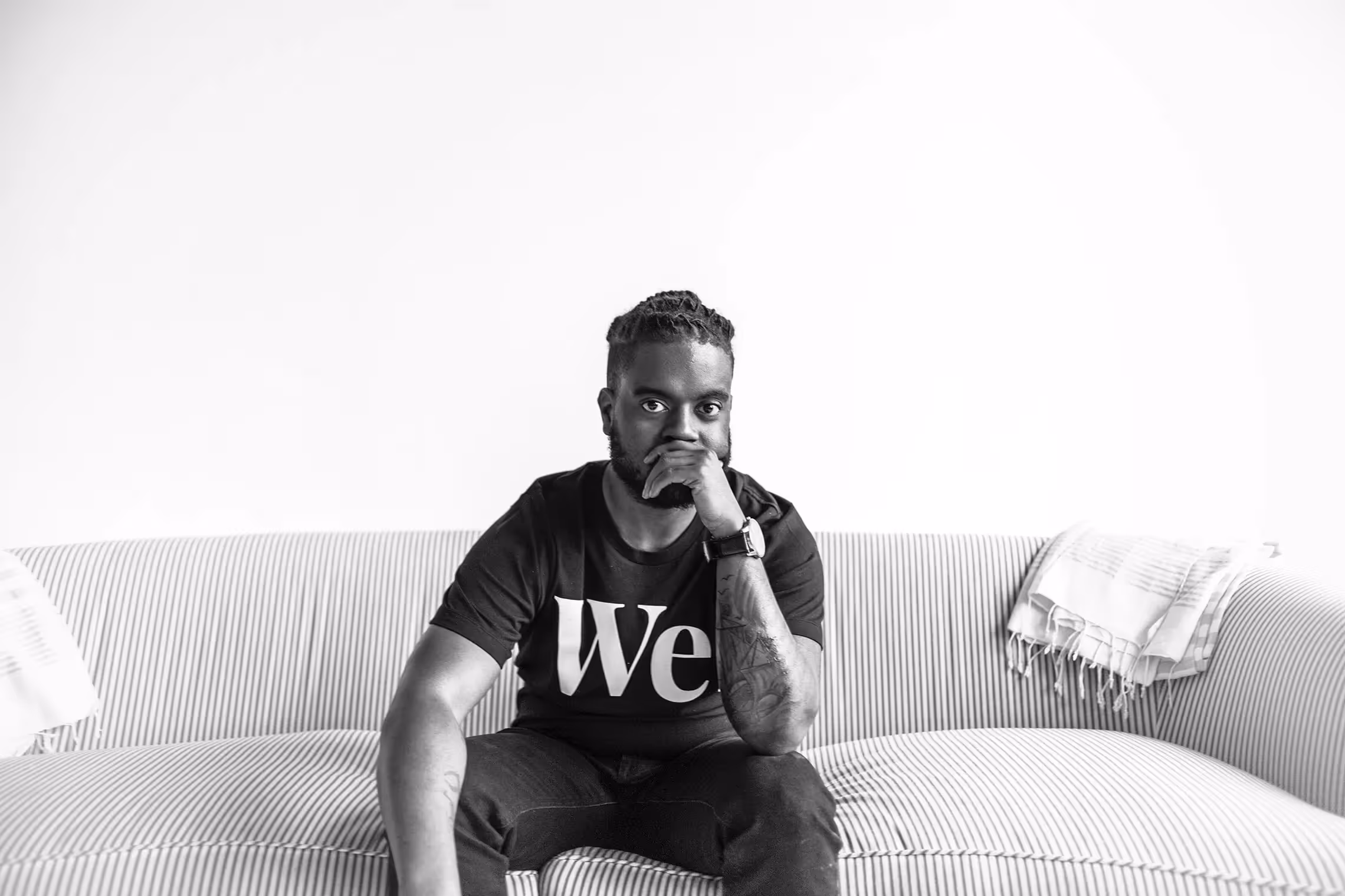 Kareem Manuel poses while wearing a "We" shirt.