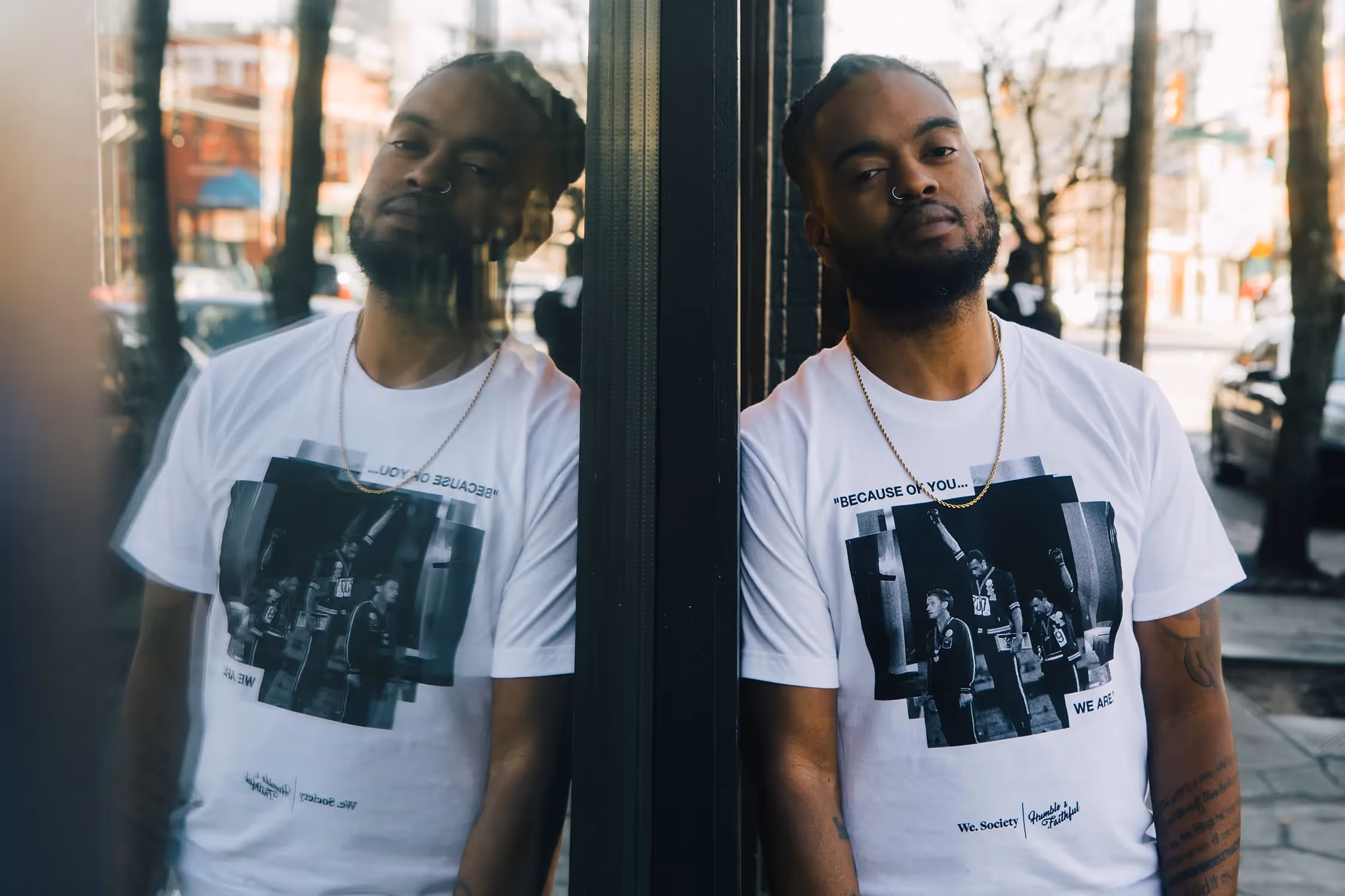 Kareem Manuel poses while wearing a "We" shirt.