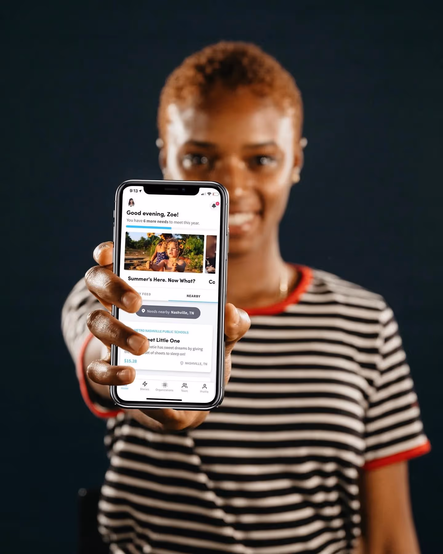 A woman holds a phone displaying the Purposity app.