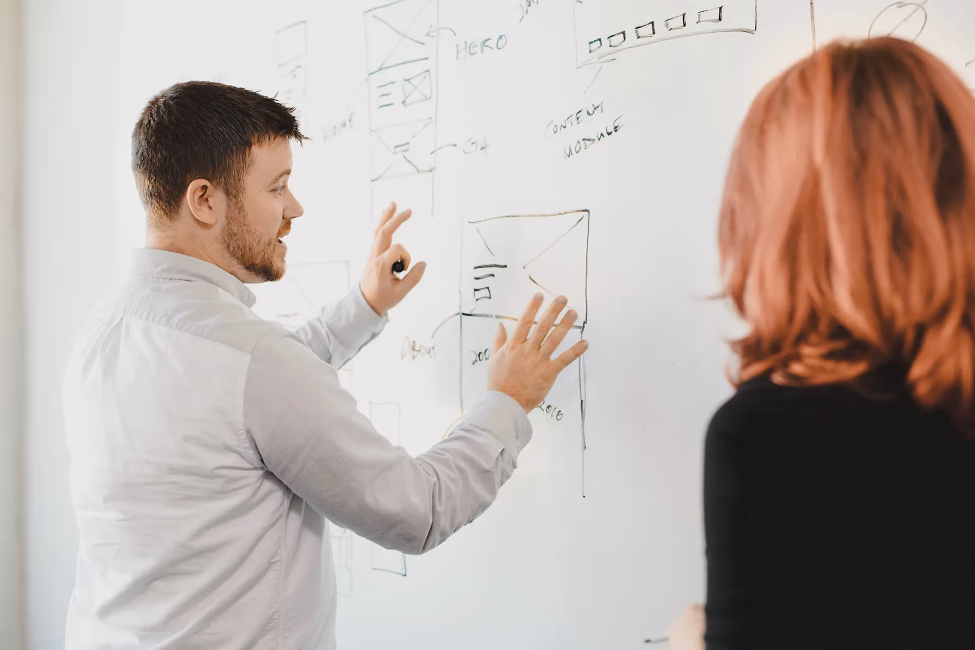 Whiteboard employees Eric Brown and Savannah Wallace collaborate at a whiteboard.