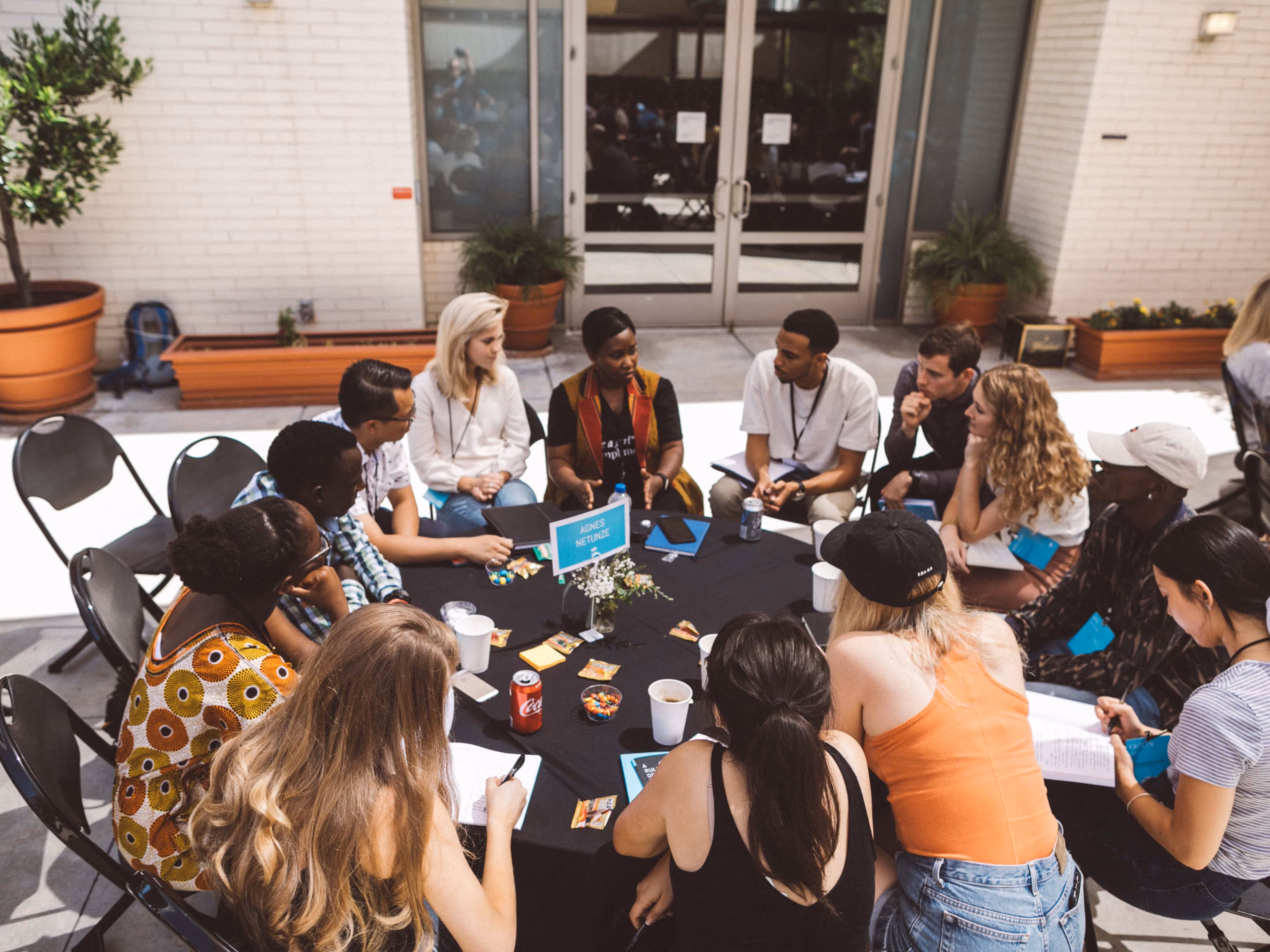 A group of Praxis fellows engages in a dialogue around a fire pit