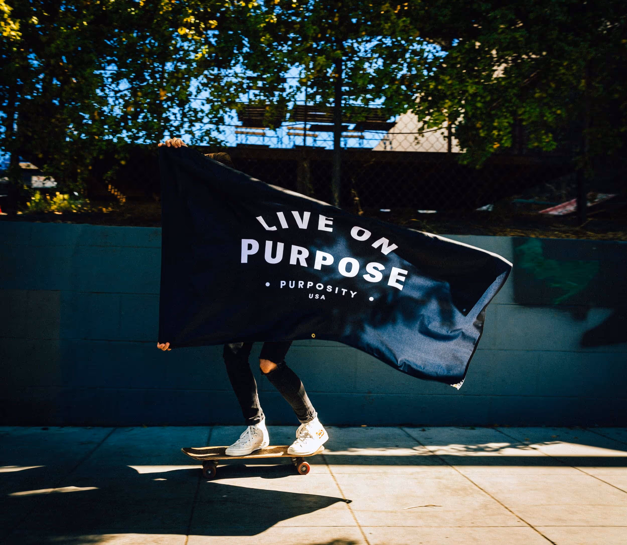 A woman holds a Purposity flag that reads "Live on Purpose"