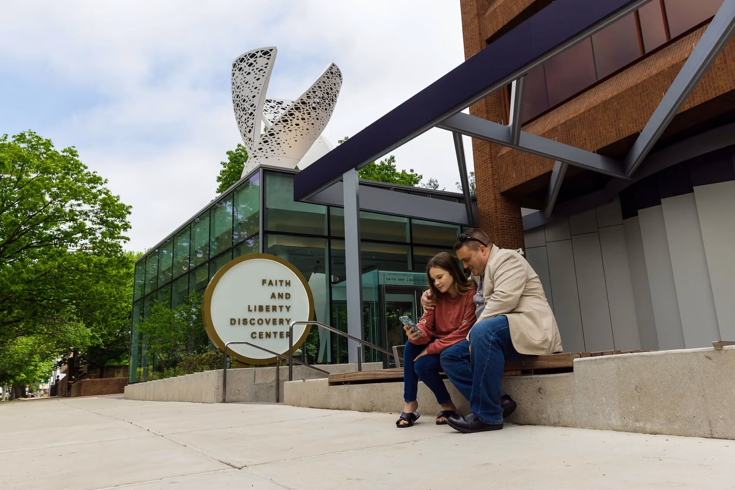 Wide angle shot of a couple sitting outside the FLDC entrance.