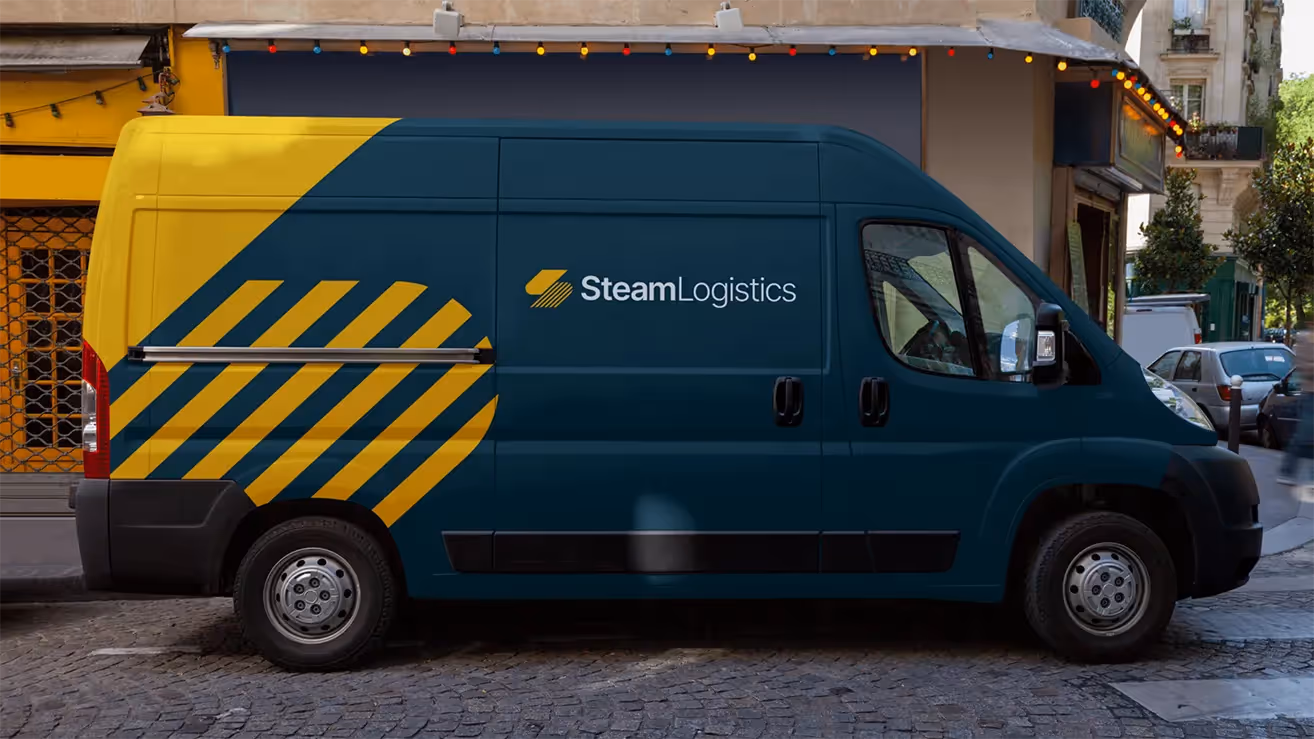 A dark blue and yellow Steam Logistics delivery van parked on a cobblestone street, featuring the company’s logo and diagonal stripe design.