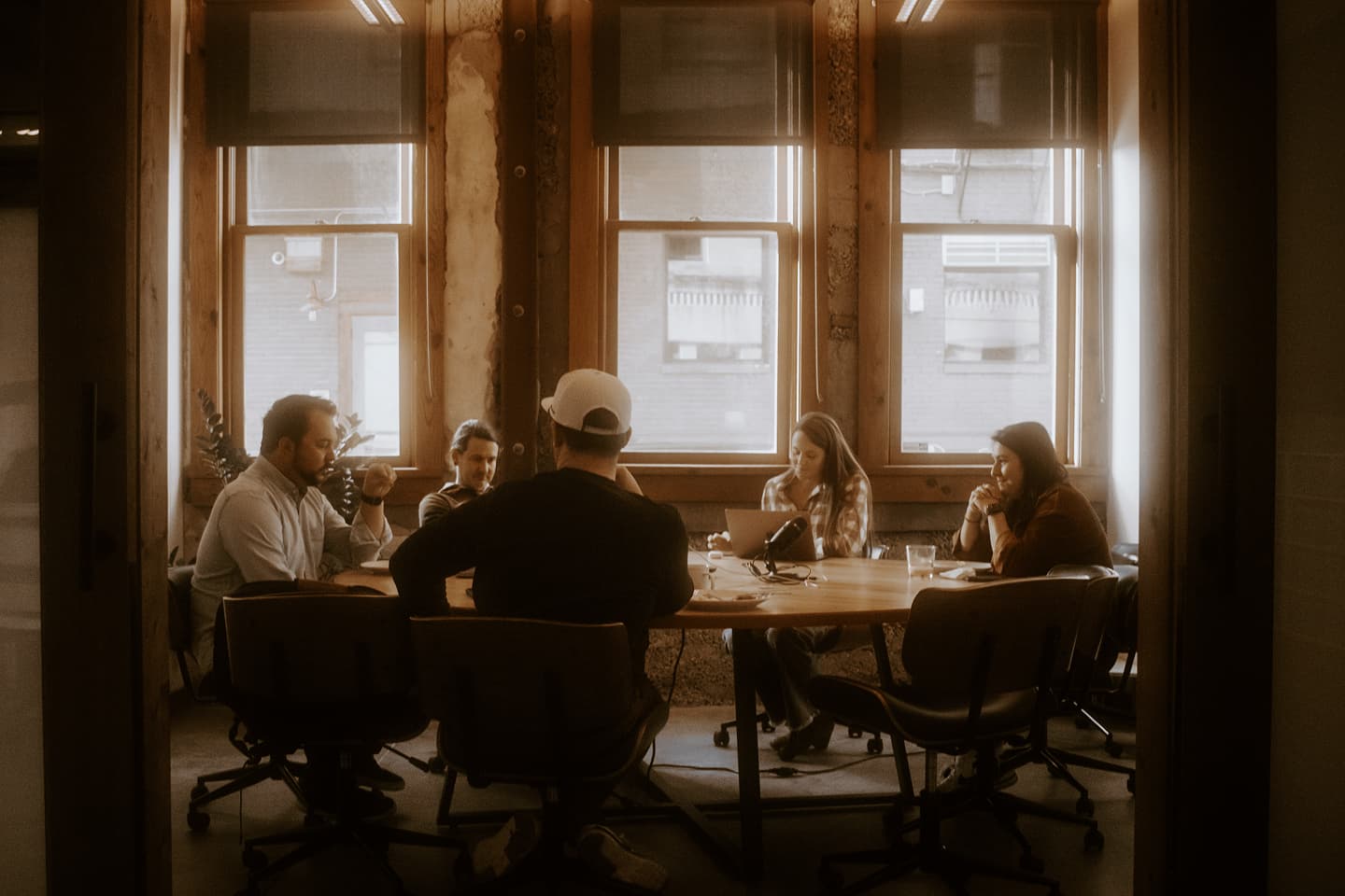 The Whiteboard team sitting around a table in meeting