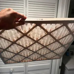 hand showing pulled air conditioner filter