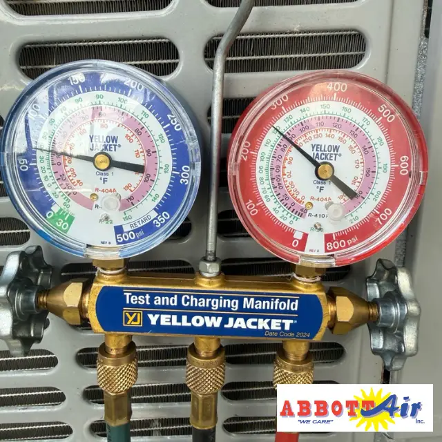 Yellow Jacket test and charging manifold with pressure gauges for HVAC refrigerant measurement.