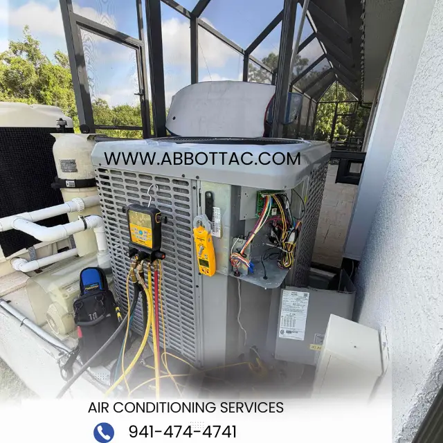 Outdoor air conditioning unit with gauges and wires, next to a pool pump and pipes in a screened area.