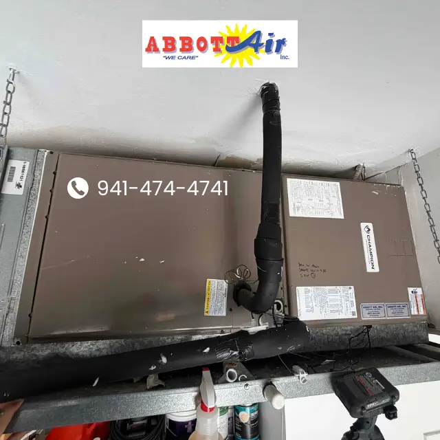 Installed brown Champion HVAC unit with black insulated pipes and Abbott Air logo and phone number overlay.
