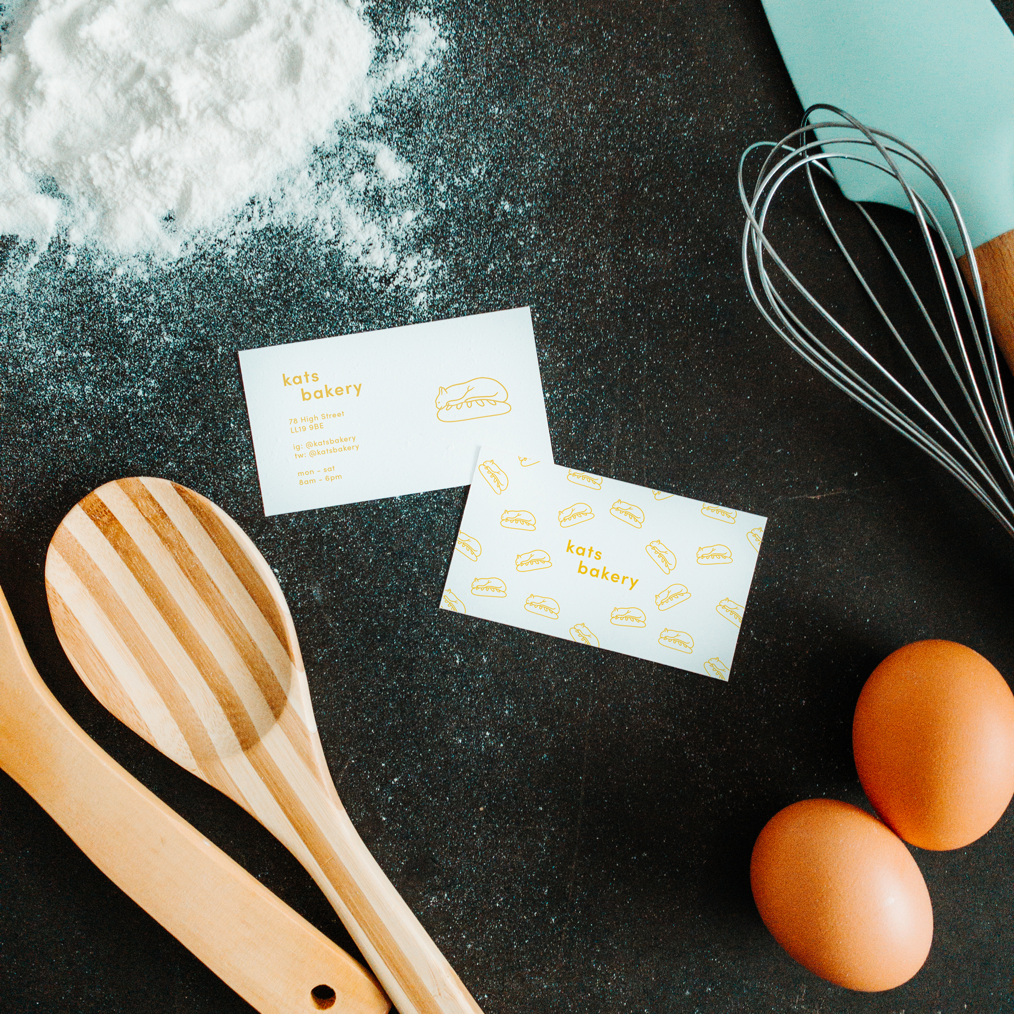 A messy bakery table with two business cards.