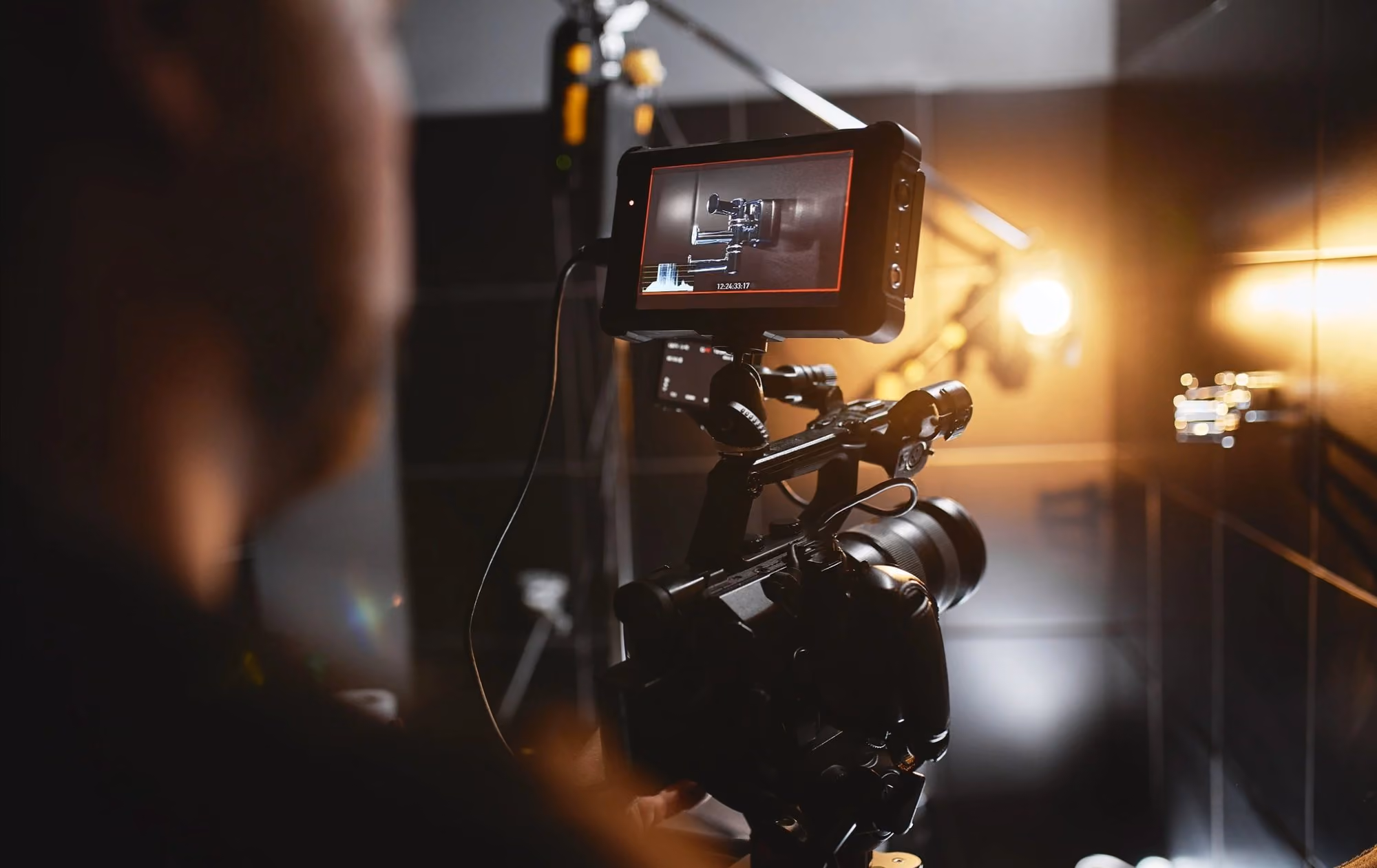 Video production crew member checking framing on a camera monitor during event coverage
