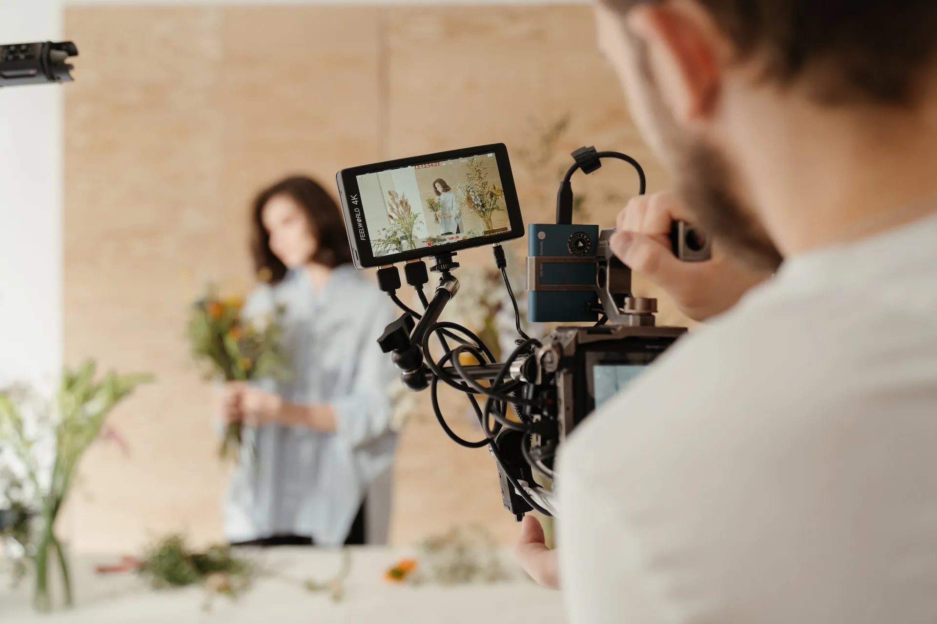 videographer filming a woman holding flowers