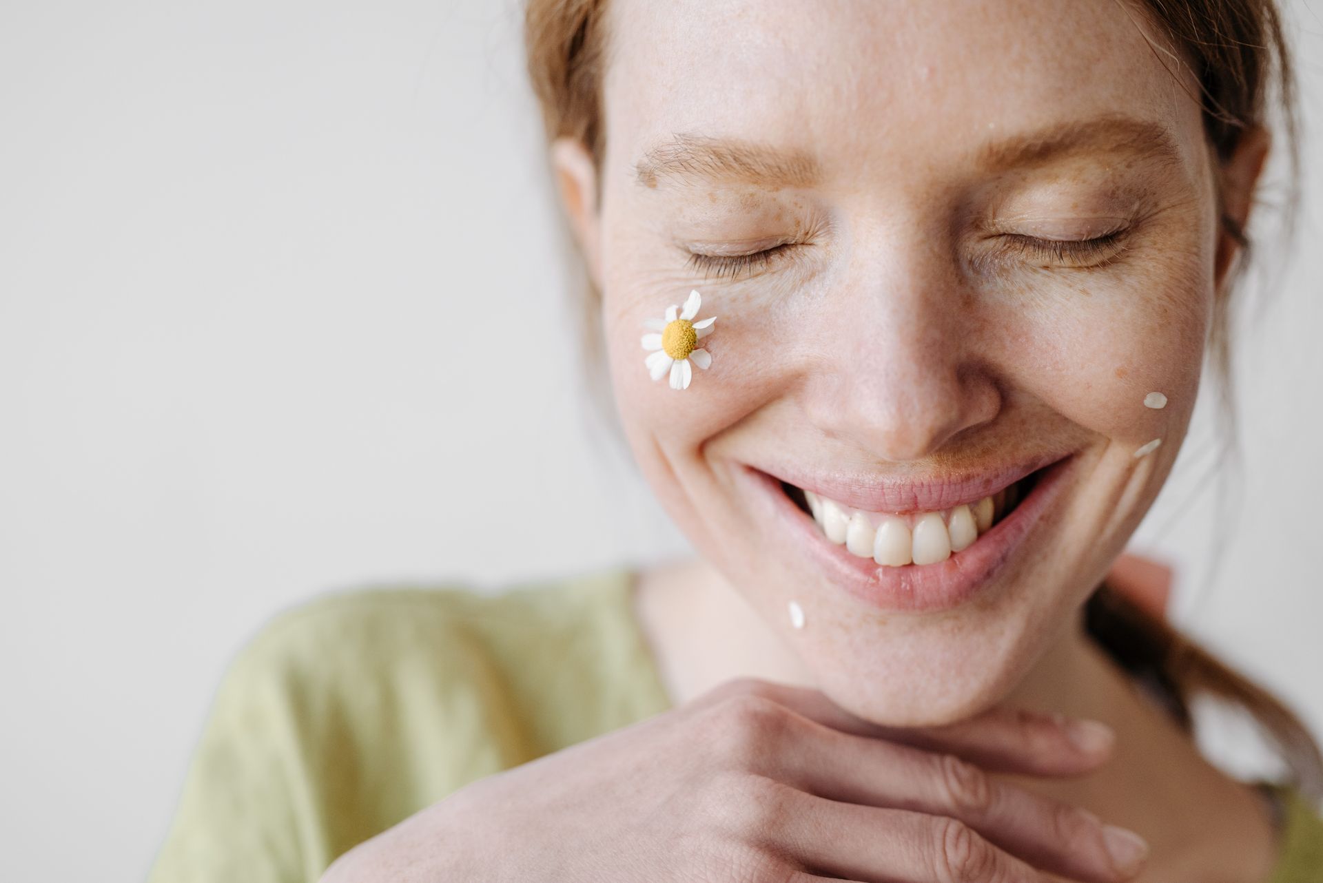 Woman smiling showing her beautiful teeth with her eyes closed while being calm and relaxed