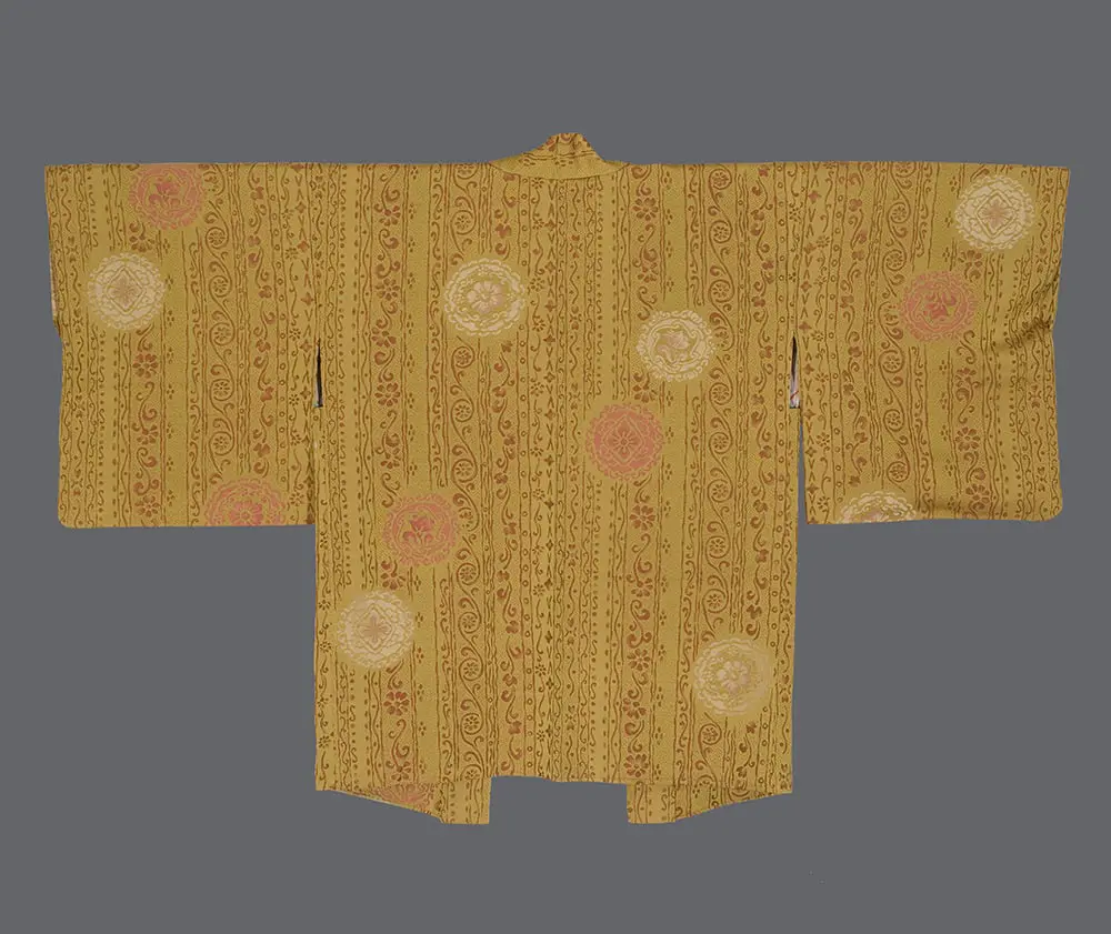 Ochre omeshi silk haori with vertical woven vine bands and scattered pink and cream floral medallion patterns.