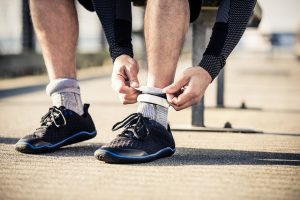 A man tying his shoelaces on a skateboard