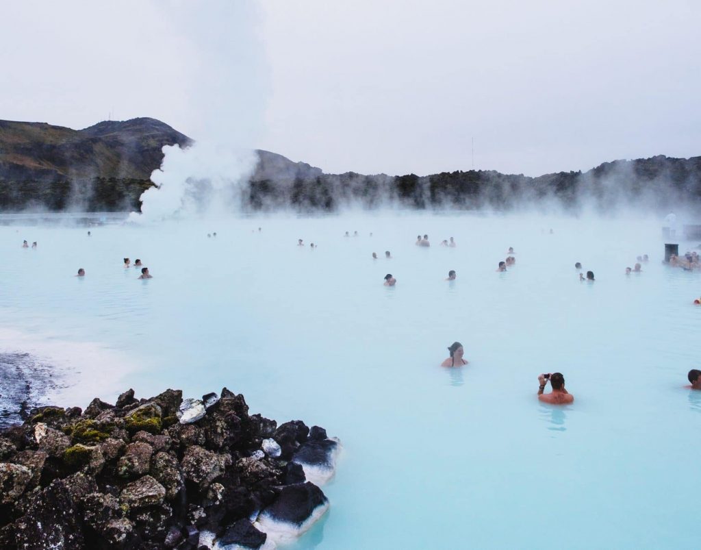 A group of people are swimming in a blue lagoon