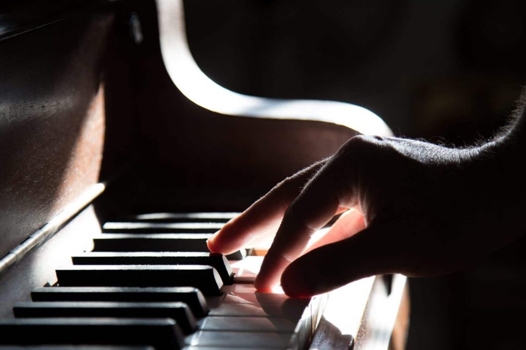 A person's hand on a piano keys