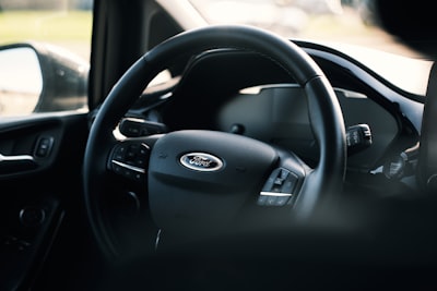 A close up of a steering wheel and dashboard of a car