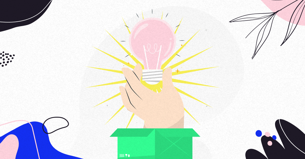 Une main tenant une ampoule au-dessus d'une boîte