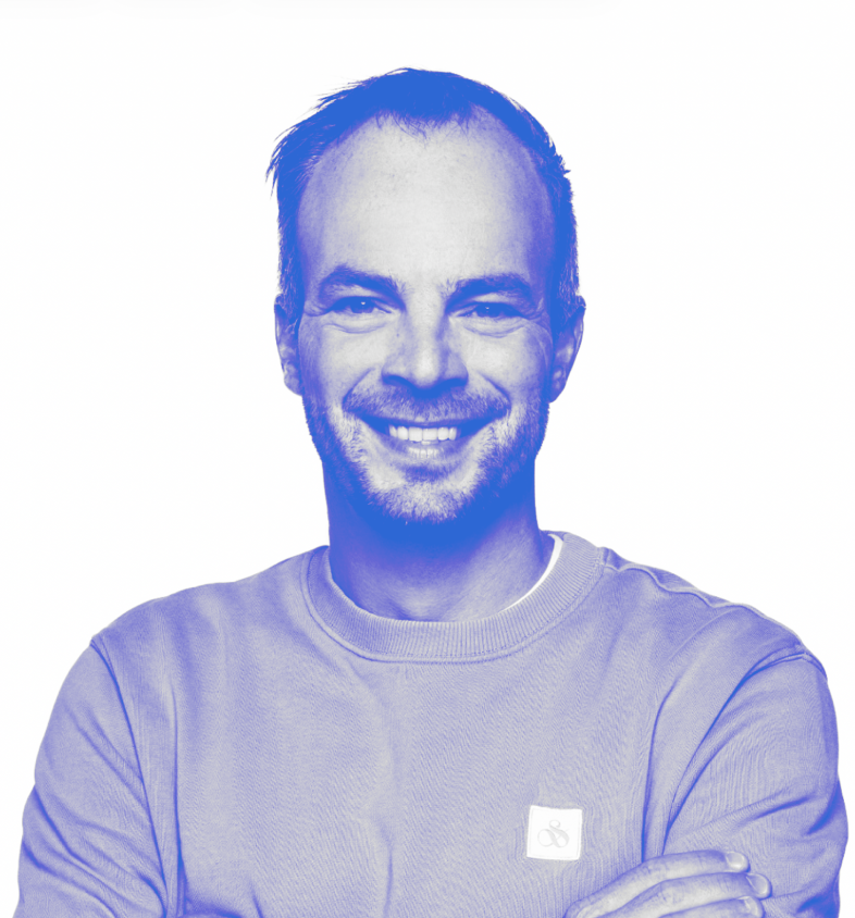 Portrait of a Roderick Meijer, a man with short hair and light facial hair wearing a light-colored sweatshirt with arms crossed against a white background.
