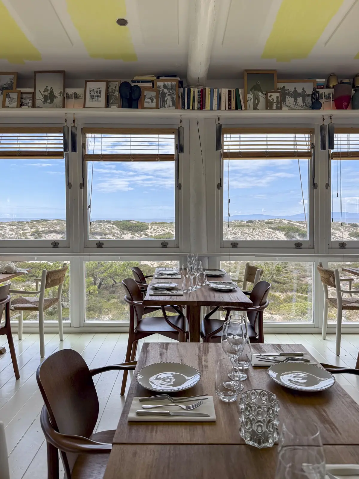 Inside Caché Comporta with windows showing view of the dunes