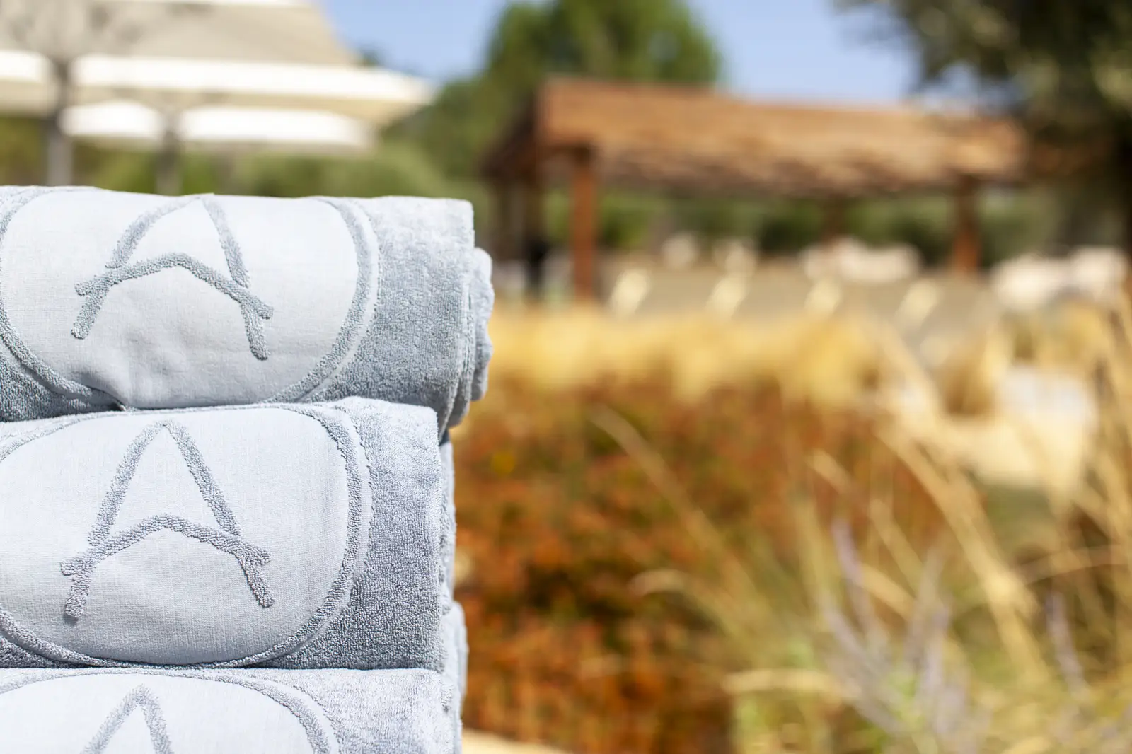 Stack of towels by the pool at Spatia Comporta, a five-star hotel retreat.