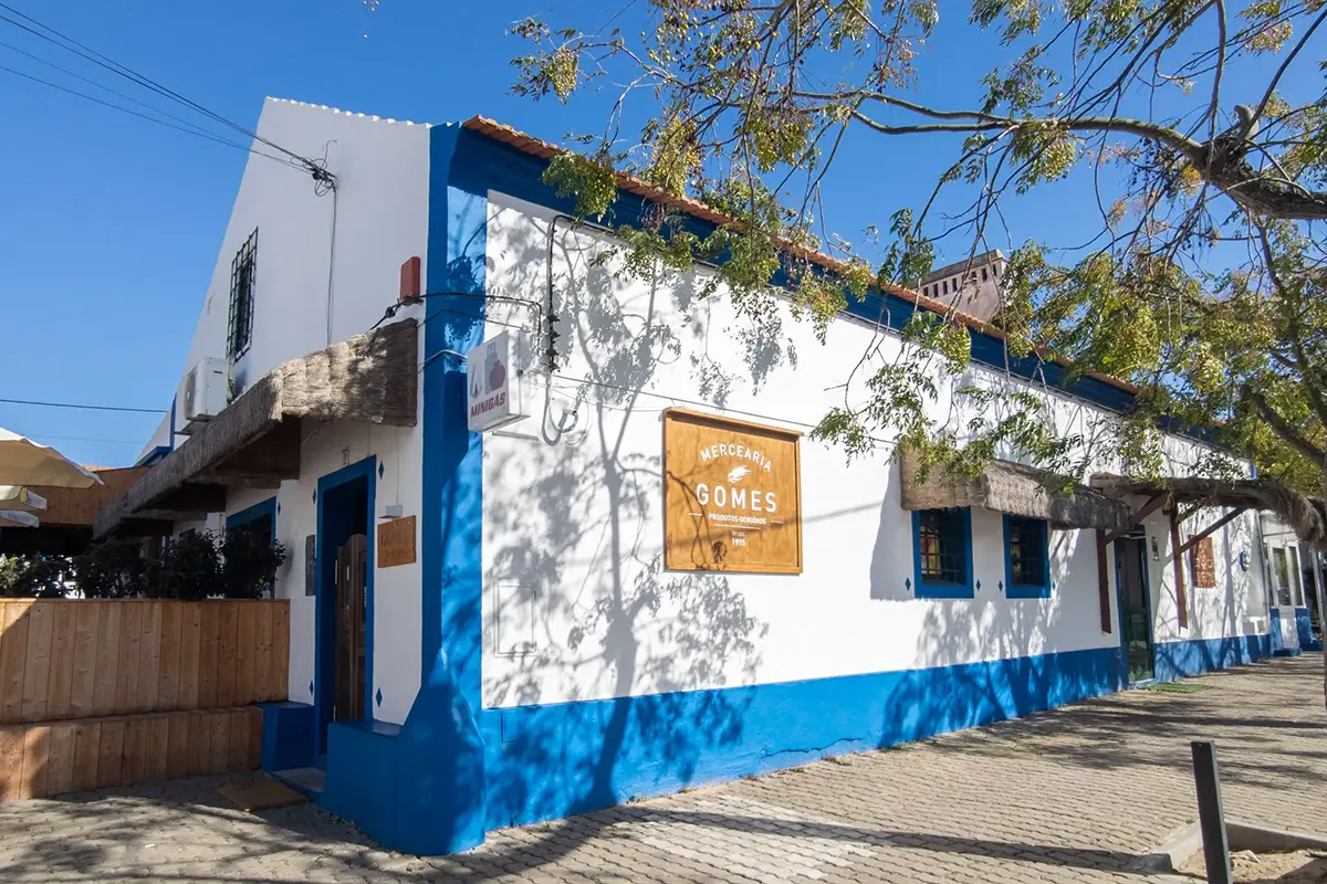 The exterior of Mercearia Gomes in Comporta Village, a white and blue traditional house