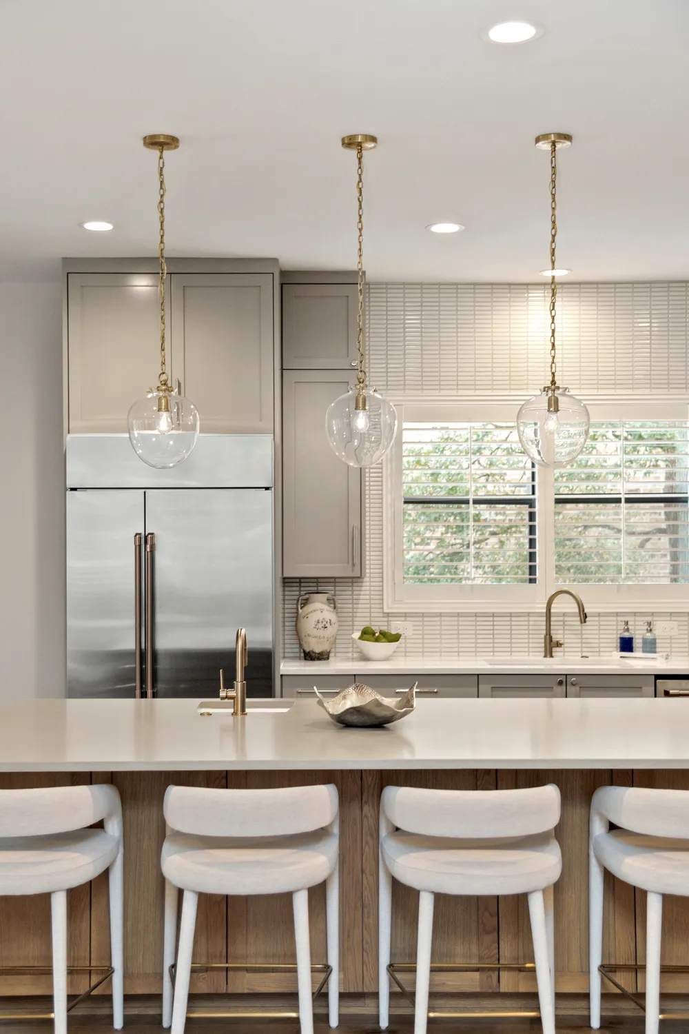 Modern Kitchen with Large Island, Glass Pendants, and Stainless Appliances