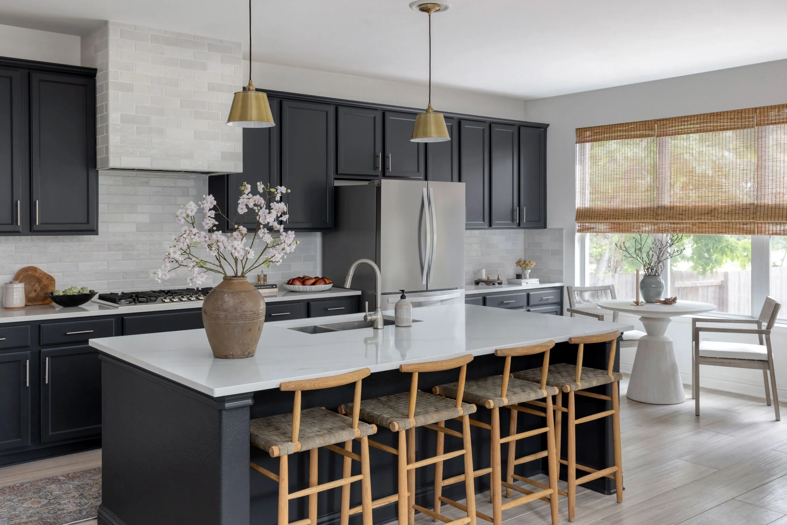 Dark Cabinets, White Counters, Island Seating, and Round Dining Table