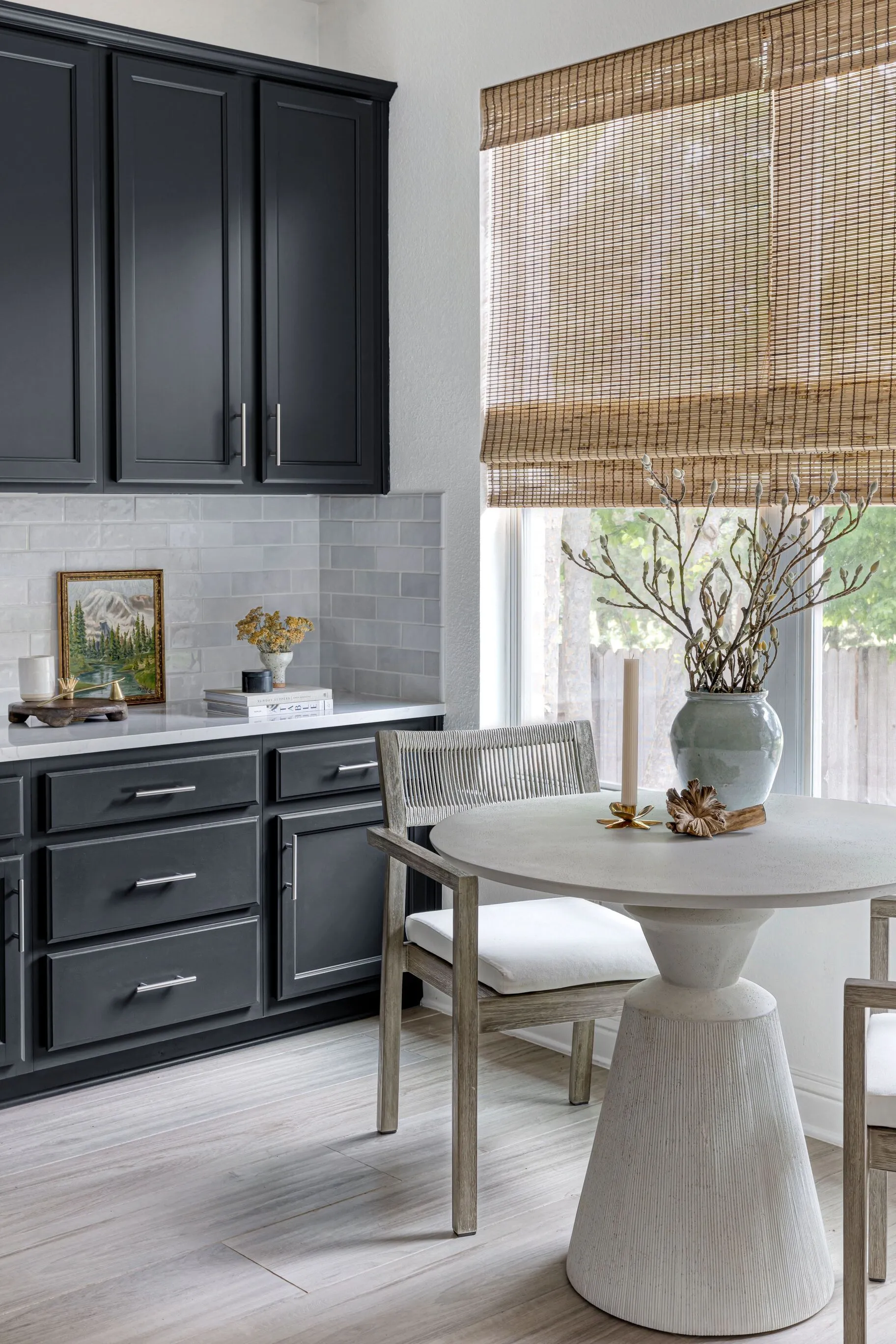 Dining Nook with Dark Cabinets, Round Table, and Roman Shade